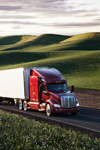 Truck-driving-past-farm-for-food-and-beverage-shipment
